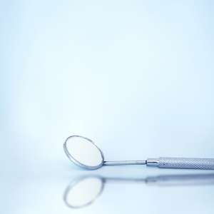A metal spoon resting on a smooth blue surface, showcasing its reflective surface and sleek design.