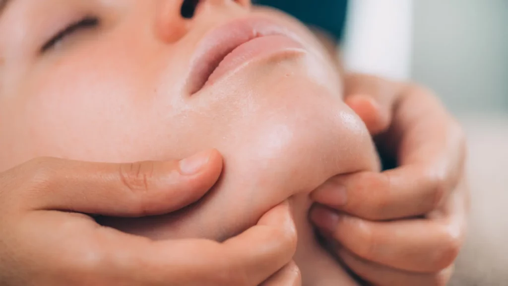 Hands massaging jawline
