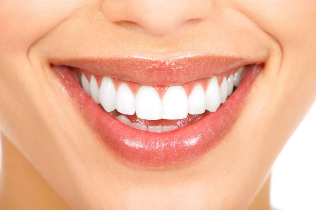 A woman with a bright smile, showcasing her white teeth, exudes warmth and happiness.