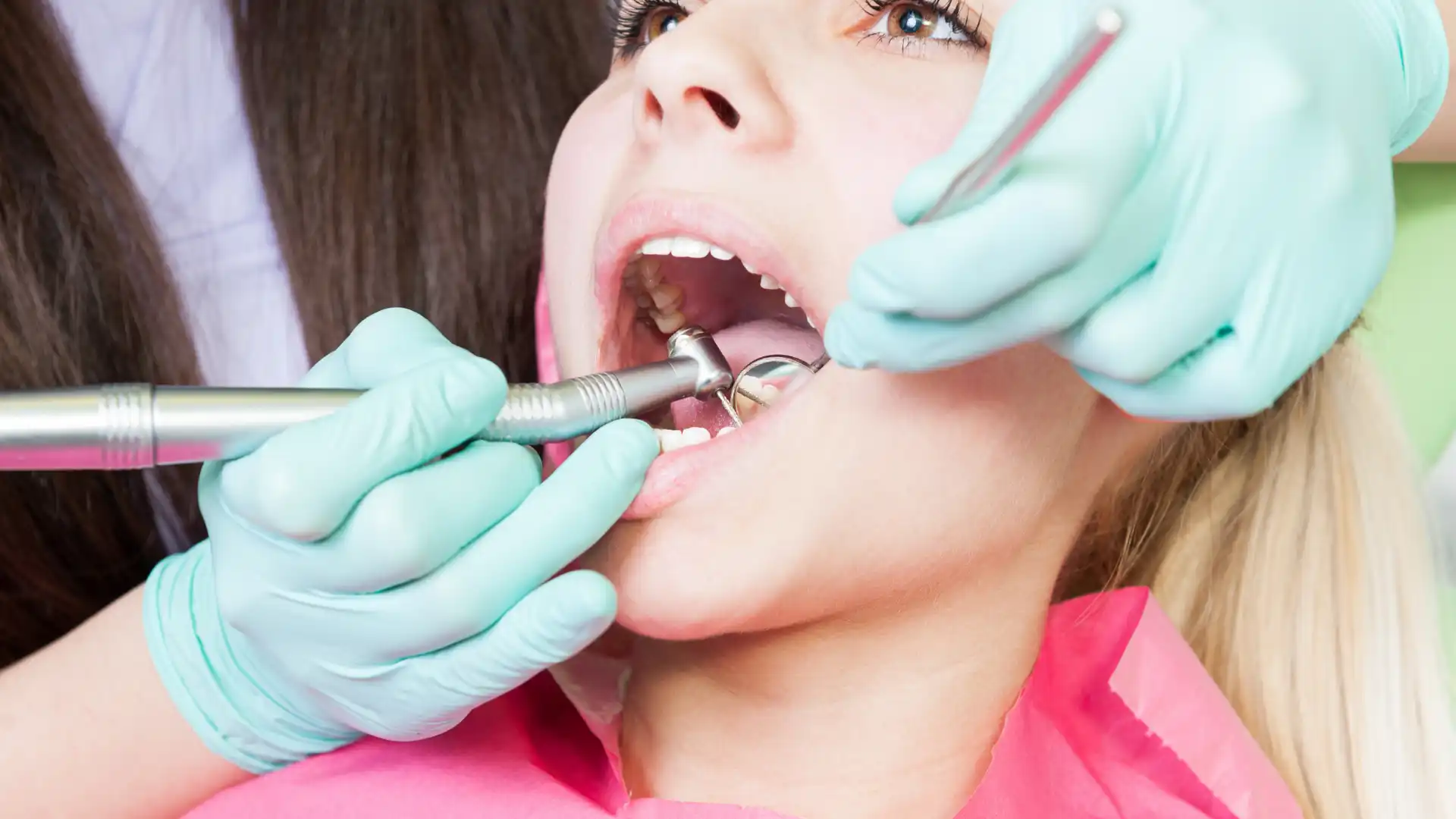 Child receiving a dental check-up with professional tools.