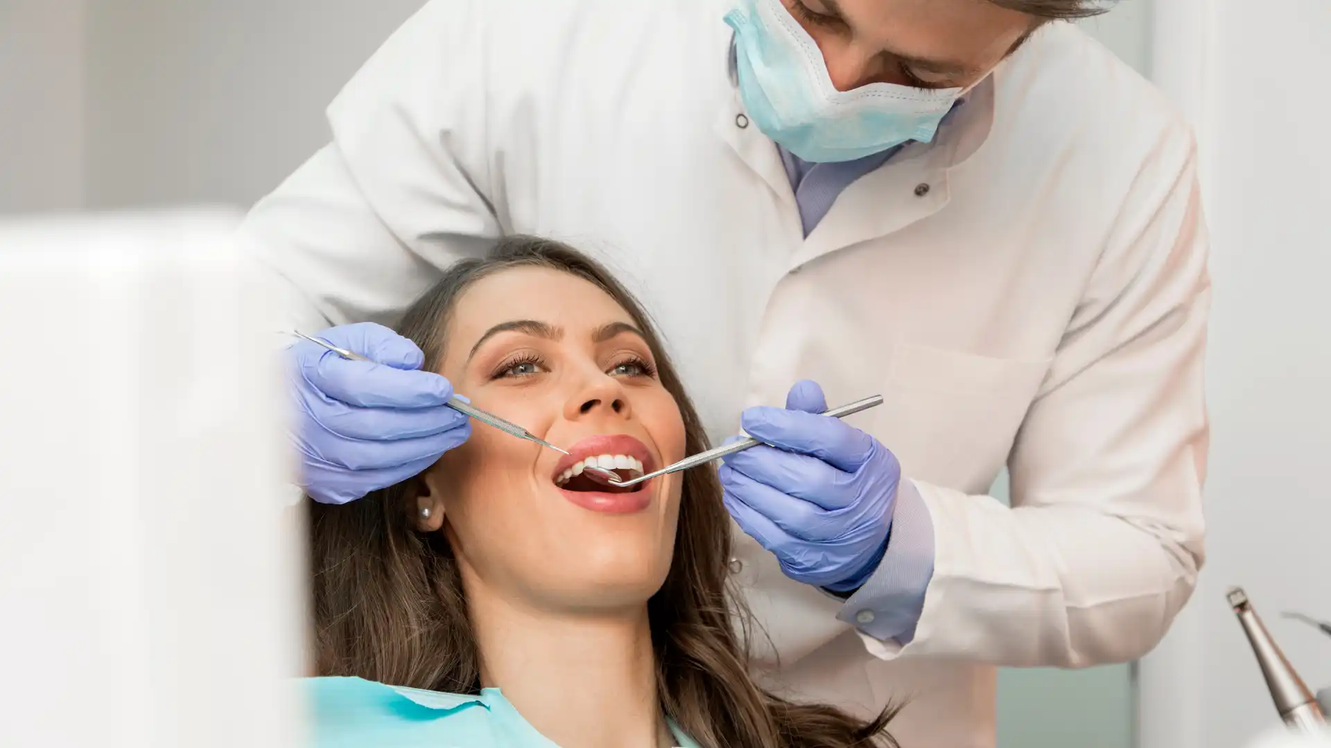 Dentist examining a woman's teeth during a dental check-up.