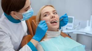 a woman sitting in a chair getting invisalign with a dentist 