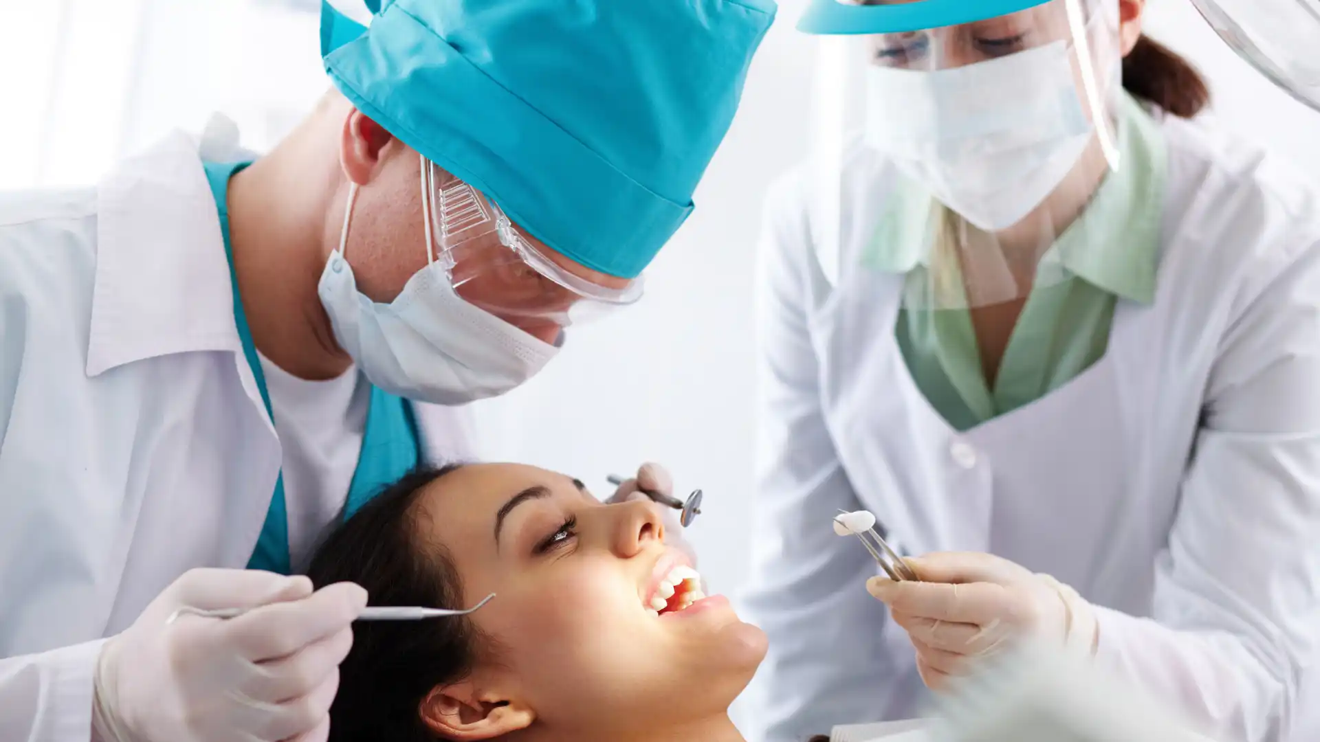 Dentists performing a dental procedure on a patient in a clinical setting