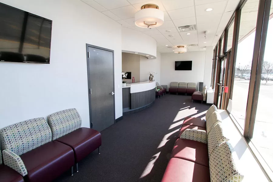 A cozy waiting room featuring comfortable couches and a television for entertainment.