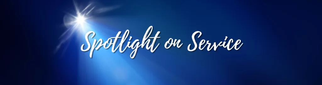 The image features the phrase "Spotlight on Service" in elegant script, illuminated by a bright spotlight against a deep blue background.